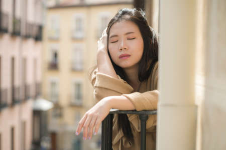 dramatic portrait of young beautiful sad and depressed Asian Japanese woman feeling unhappy and worried suffering some problem going through depression and anxiety crisisの写真素材