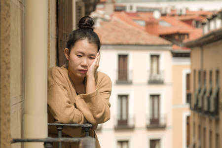 dramatic portrait of young beautiful sad and depressed Asian Japanese woman feeling unhappy and...