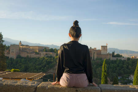back portrait of young beautiful and relaxed woman having Summer holidays in Spain enjoying cheerful beautiful view at Alhambra of Granada in tourism travel and lifestyle conceptの写真素材