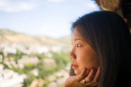 lifestyle portrait of young beautiful and happy Asian Korean tourist woman having Summer holidays in Europe enjoying cheerful visiting beautiful Alhambra of Granada in Spainの写真素材