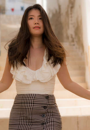 outdoors lifestyle portrait of young beautiful and happy Asian woman - attractive Chinese girl...