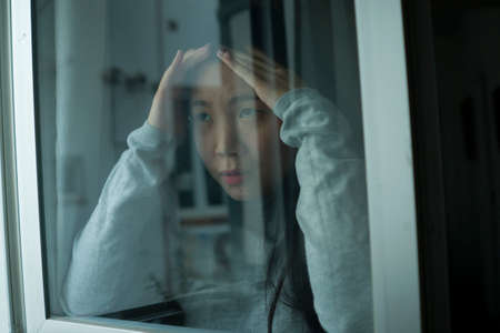 young sad and depressed Asian Korean girl scared and worried during covid19 lockdown and stay home...