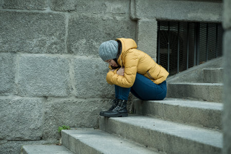 dramatic lifestyle portrait of young attractive sad and depressed Japanese woman in winter hat...