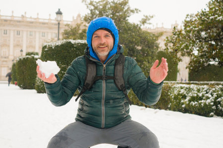 urban winter lifestyle portrait of young happy and attractive tourist man walking cheerful in city...