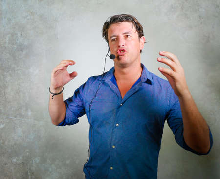 young attractive and successful man giving motivation coaching speech talking through headset gesturing confident at corporate business success seminarの写真素材