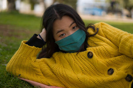 young Asian woman in city park during  - outdoors lifestyle portrait of happy and pretty Chinese...