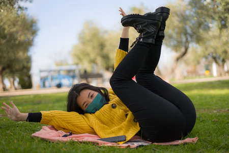 young Asian woman in city park during   - lifestyle portrait of happy and pretty Korean girl in face...