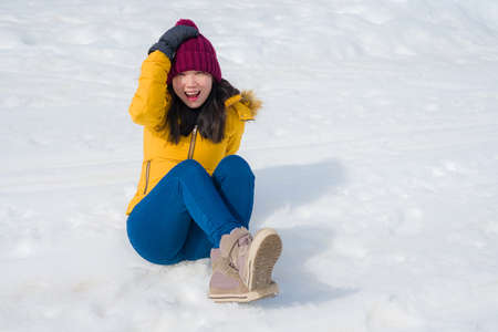 Winter holidays in the snow - lifestyle portrait of young happy and beautiful Asian Korean girl...