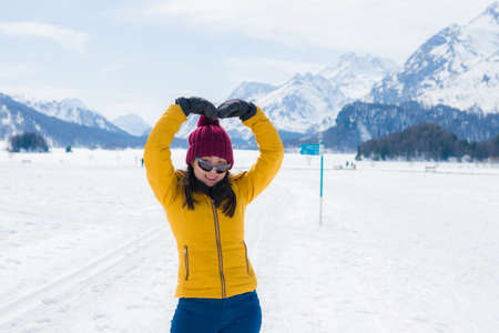 Winter holidays in the snow - lifestyle portrait of young happy and beautiful Asian Chinese girl...