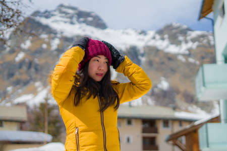 winter lifestyle portrait of young happy and attractive Asian Japanese woman at beautiful snow...