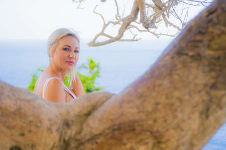 Summer lifestyle portrait of young attractive and sexy blond woman in bikini enjoying beach holiday at tropical paradise under the sun in Bali Islandの写真素材