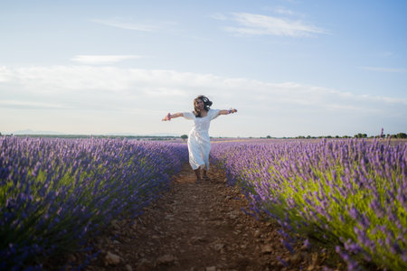 outdoors romantic portrait of young happy and attractive woman in white summer dress enjoying carefree at beautiful lavender flowers field in travel and holiday conceptの写真素材