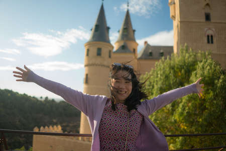 Young Asian woman outdoors lifestyle portrait -  happy and beautiful Japanese girl enjoying  fairytale style castle from viewpoint during holiday travel in Europeの写真素材