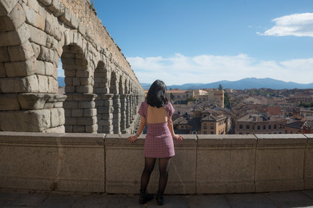 woman at Segovia acueducto viewpoint during vacation in Spain - young happy woman visiting heritage aqueduct in Segovia enjoying holidays travelの写真素材