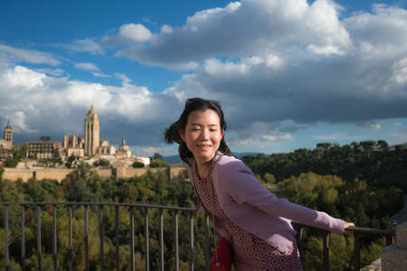 Young Asian woman outdoors lifestyle portrait -  happy and beautiful Chinese girl enjoying old town panorama from viewpoint during holiday travel in Europe smiling cheerfulの写真素材