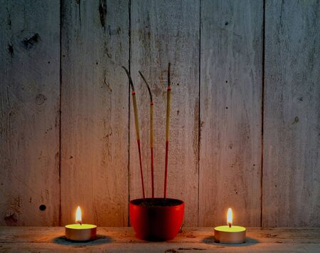 incense sticks with candle flame on wooden background,pray in thai traditional