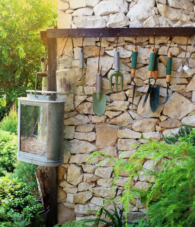 gardening conception and gardening tool hanging on the stone wallの写真素材