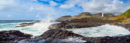 Panorama landscape of waves splashing on the rocky shore at Kukii Point lighthouse, Kalapaki, Kauai, Hawaii, USAの写真素材