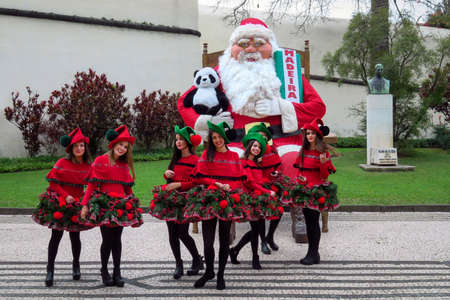 Funchal, Madeira, Portugal - 12/13/2015: group of Christmas girls models posing with huge Santa Clausのeditorial素材