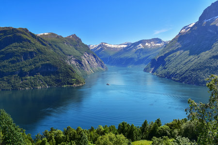 Cruise ship sailing immense fjord water in impressive mountain landscape on a sunny summer day. Norway, Scandinavia, Europeの写真素材