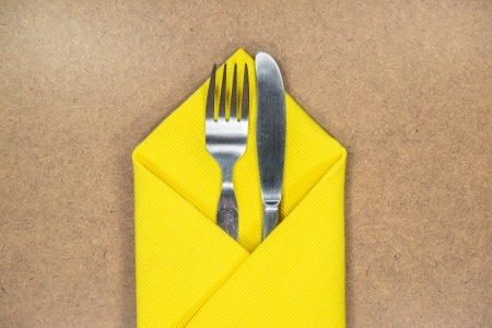 fork and knife in yellow napkin の写真素材