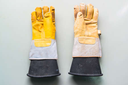 Worker s dirty leather gloves on white background の写真素材