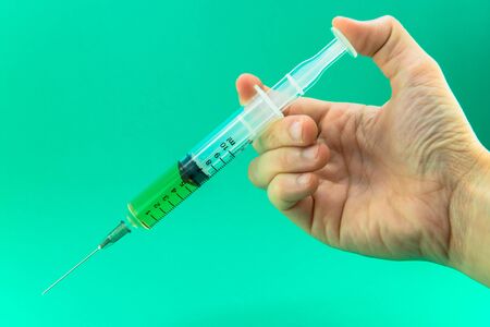 Syringe with a medicine in a female handsの写真素材