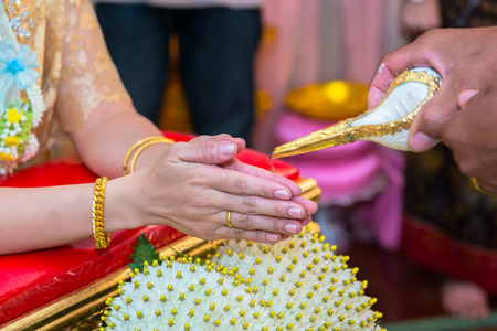 hands pouring blessing water into bride s hands, Thai wedding ceremonyの写真素材