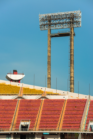 stadium, red seats on stadium steps bleacher with spot light pole の写真素材