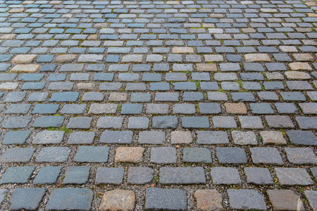 Old grey pavement of cobble stones in a circle pattern in an old medieval european townの写真素材