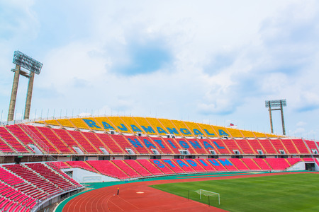 stadium, red seats on stadium steps bleacher with spot light poleのeditorial素材