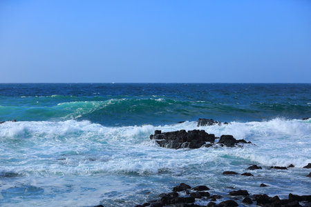 Cool waves crashing at Yongdam Beach in Jeju Island