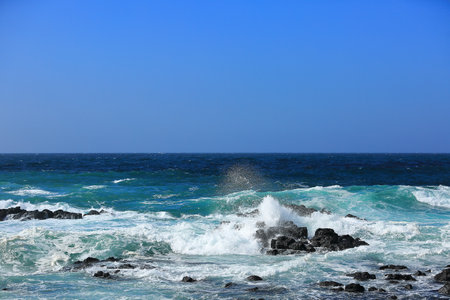 Cool waves crashing at Yongdam Beach in Jeju Islandの写真素材