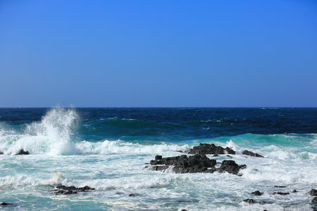 Cool waves crashing at Yongdam Beach in Jeju Islandの写真素材