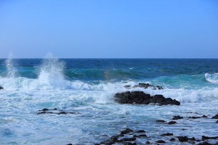 Cool waves crashing at Yongdam Beach in Jeju Islandの写真素材
