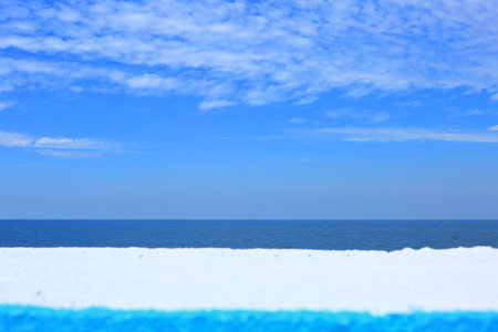 The blue sea and sky of peaceful Jeju Island seen over the breakwaterの写真素材