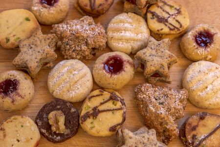 Several christmas cookies on rustic wooden plate