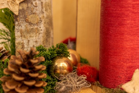 Christmas decoration with red candle and golden baubleの写真素材