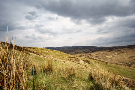 Scottish highlands with cloudy sky and sunraysの写真素材