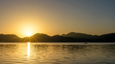 Beautiful sunrise over lake with mountains rangeの写真素材
