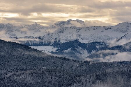Mountain range with clouds and bright sunlightの写真素材