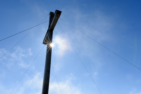 Summit cross with sun star in front of blue skyの写真素材
