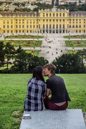 Vienna, Austria, September , 15, 2019 - Couple talking, dating and kissing at the hill in front of Schonbrunn Palace , a former imperial summer residence of Habsburg monarchsのeditorial素材