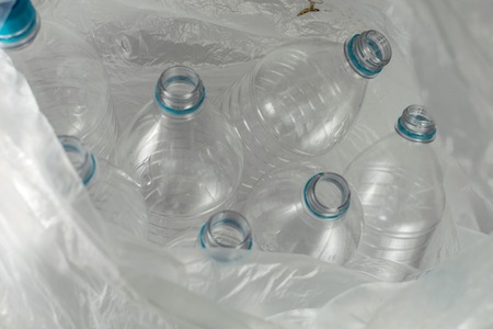 Inside an open transparent plastic bag with several empty bottles of liter and a half mineral water,...