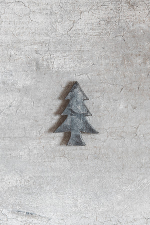 Little wooden Christmas tree ornament on a wooden background. Winter greeting card.の写真素材