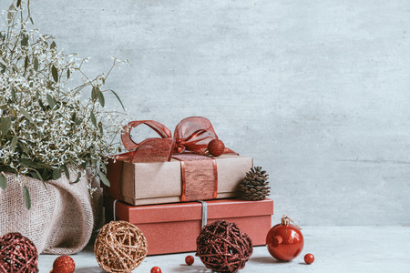 Beautiful Christmas background with decorations and gift boxes on wooden board. Red ribbon, pine cones, baubles. Copy space, greeting card.の写真素材