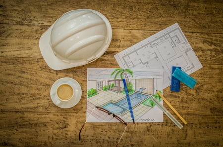 Objects of designer, low plant, hard hat, ruler and miscellaneous objects on wooden table.の写真素材