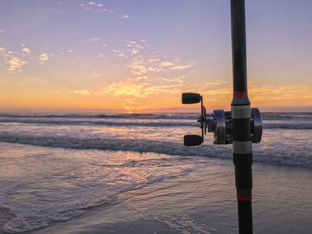 Fishing rod on beach at sunset, surfing cast.の写真素材