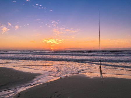 Fishing rod on beach at sunset, surfing cast.の写真素材