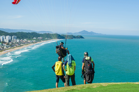 Students practicing paragliding on the hill.